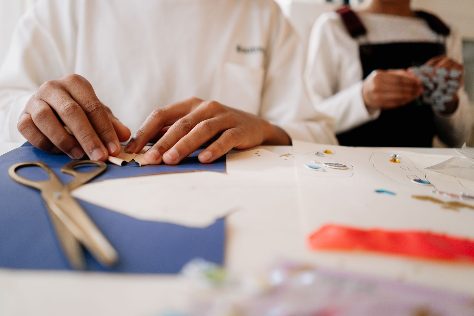 Children engaging in arts and crafts with paper and scissors, focusing on creativity and fun.