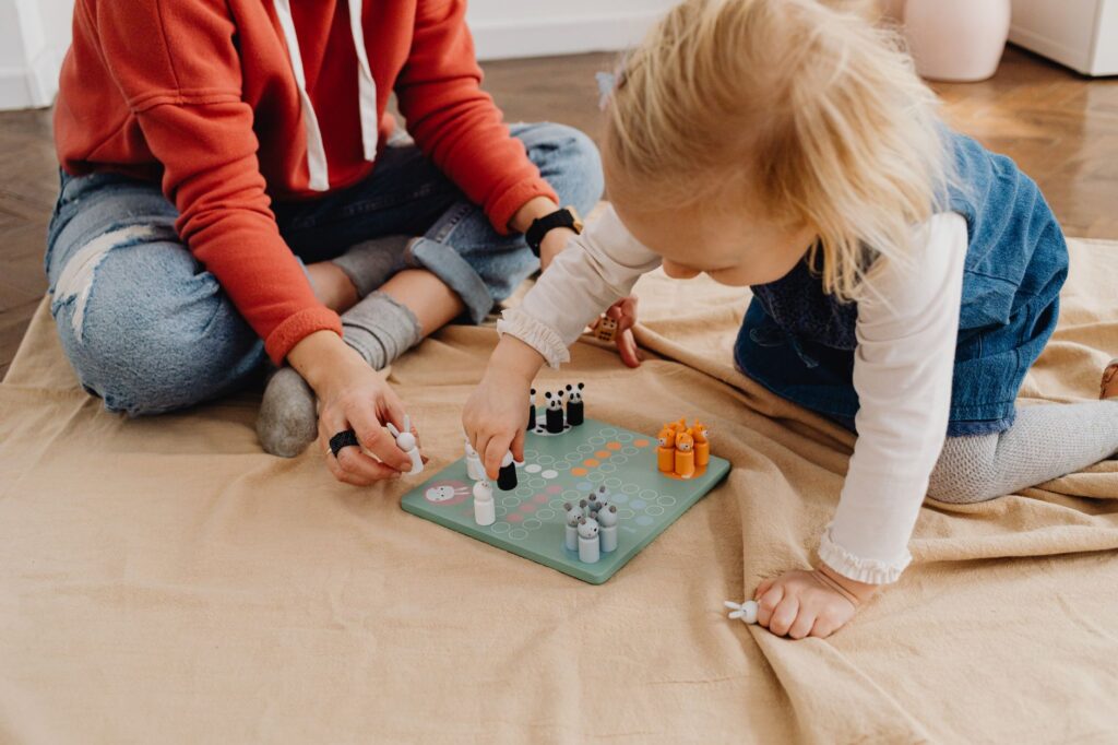 A mother and daughter bonding over a board game indoors, capturing family fun and togetherness.