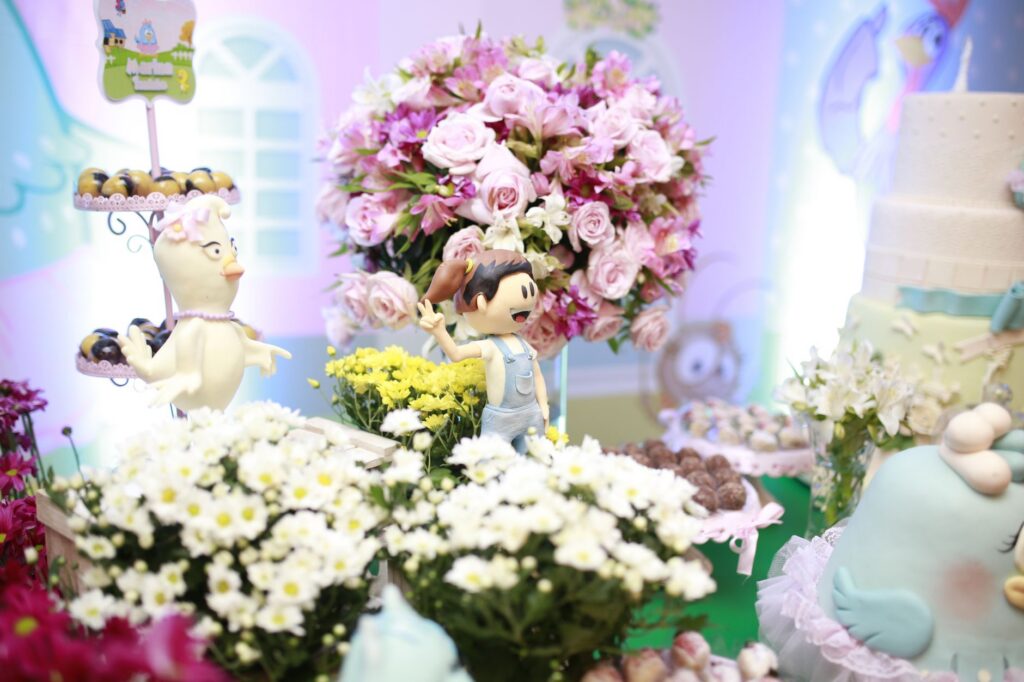 Charming birthday party with floral arrangements and playful figurines.