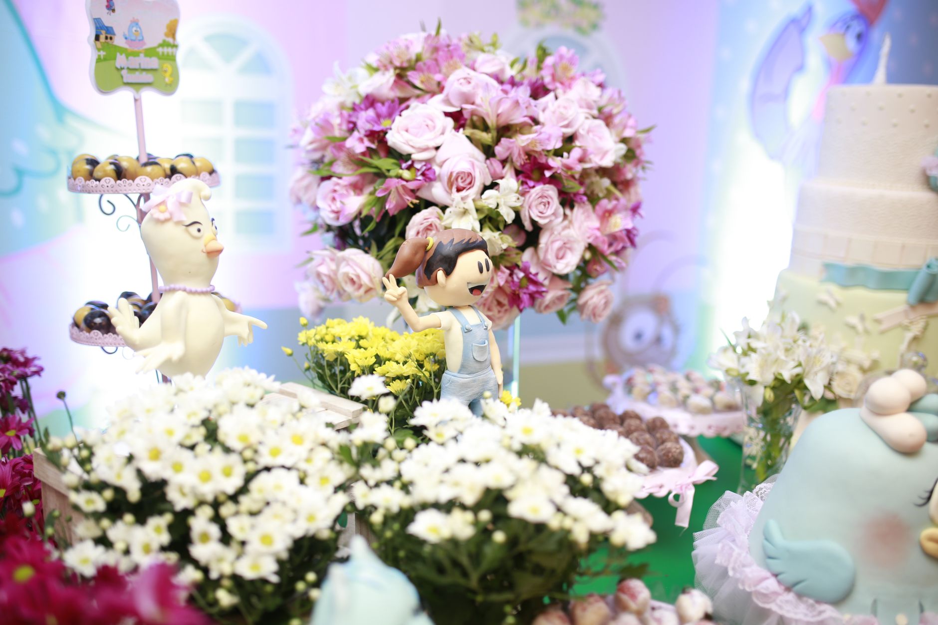 Charming birthday party with floral arrangements and playful figurines.